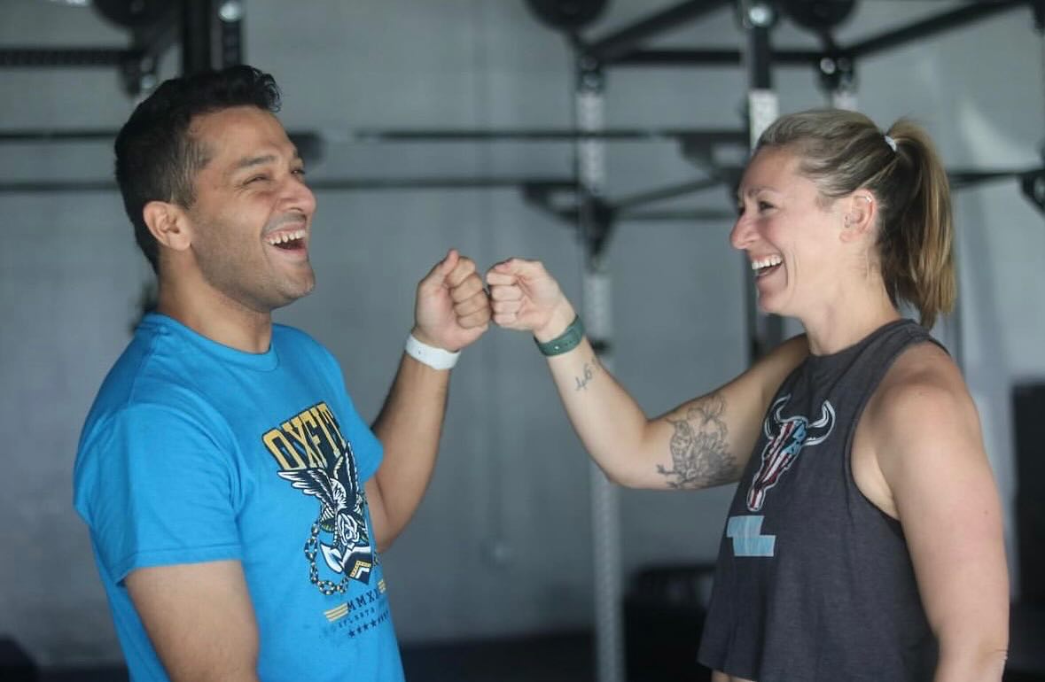 OxFit teammates sharing a smiling fist bump